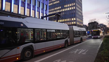 Autobús-Eléctrico-Cargándose-En-La-Ciudad-En-Otoño,-El-Vehículo-Detrás-Está-Esperando-Para-Recargar----Transporte-Público,-Gran-Plano