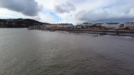 Panning-right-shot-of-the-seafront-at-Teignmouth-Devon-England-on-a-stormy-overcast-day