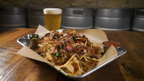 Brewery-carnitas-nachos-slathered-in-queso-paired-with-a-light-beer,-slider-4K