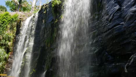 Wasser,-Das-An-Sonnigen-Tagen-Die-Steile-Kante-Der-Klippe-Hinunterfällt---Kerikeri-Wasserfälle,-Neuseeland