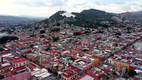 Luftaufnahme-Der-Stadt-Des-Historischen-Zentrums-Von-Oaxaca-In-Mexiko,-Gefilmt-Von-Einer-Drohne-Mit-Rückwärtsverschiebung,-Zeigt-Das-Veranstaltungszentrum-Von-Oaxaca-Auf-Einem-Hügel