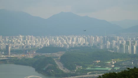 Boeing-Ch-47-Chinook-Frachthubschrauber-Fliegt-über-Seoul-Auf-Urbaner-Stadtskyline-Und-Berghintergrund-An-Dunstigen-Tag,-Blick-Von-Der-Acha-bergspitze-Aus-Der-Luft
