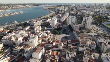 Antenne-Weit-über-Städtischem-Stadtbild,-Gebäude-Der-Innenstadt-Von-Portimao-Am-Fluss-Arade,-Portugal