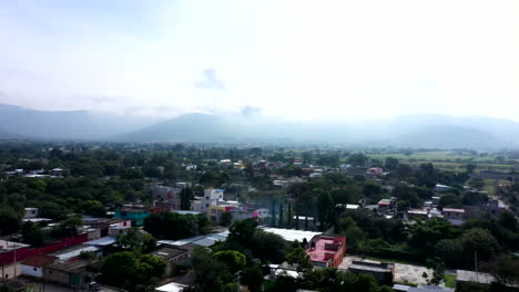 Aerial-view-of-the-suburbs-of-the-city-of-Oaxaca-in-Mexico,-filmed-by-a-drone-with-vertical-displacement-with-foggy-atmosphere