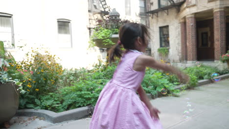 Asian-girl-playing-with-bubbles-in-the-yard,-childhood-games-in-the-courtyard