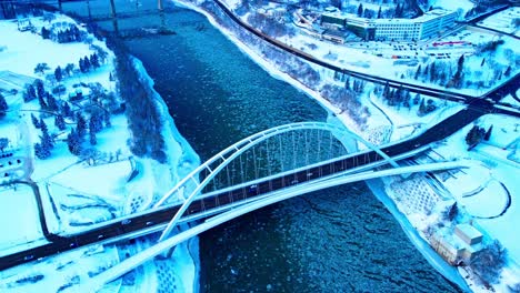 4k-Winter-Aerial-birds-view-over-the-Walter-Dale-modern-iconic-tied-arch-bridge-amber-full-length-school-bus-approaches-the-one-way-crossing-over-North-Saskatchewan-River-reflecting-off-the-water1-2