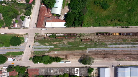 Aerial-close-up-view-of-the-train-tracks-in-the-suburbs-of-the-city-of-Oaxaca-in-Mexico,-filmed-by-a-drone-with-vertical-displacement