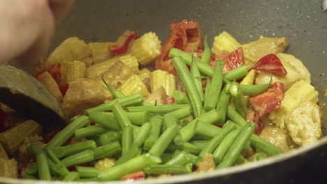 Hinzufügen-Frischer-Grüner-Bohnen-Zu-Einem-Köstlichen-Thai-Hähnchen-Curry,-Das-Im-Wok-Gekocht-Wird