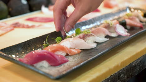 Chef-De-Sushi-Coloca-Brotes-De-Guisantes-Como-Decoración-En-Un-Plato-Tradicional-De-Nigiri,-Cierre-Hd