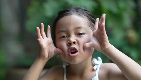 Asiatisches-Mädchenporträt,-Das-Gesichter-Zur-Kamera-Macht,-Sich-Verspottet-Oder-Aus-Der-Nähe-Neckt