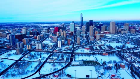 Winter-snow-covered-downtown-East-Side-Edmonton-Alberta-Canada-with-hardly-any-traffic,-nobody-outside-on-a-clear-sunny-afternoon-overlooking-the-baseball-diamond-and-highways-connecting-to-roads