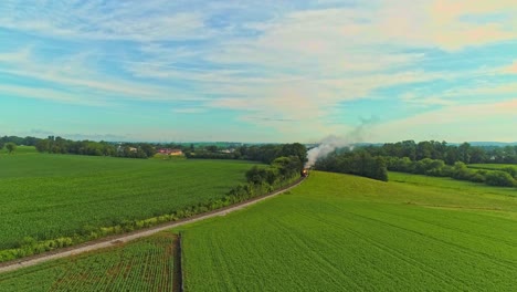 Luftlandschaft-Von-Ackerland-Und-Eine-Antike-Dampfmaschine-Fährt-An-Einem-Frühen-Sommermorgen-Durch-Die-Maisfelder