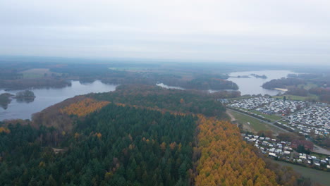 Luftaufnahme-Des-Waldes-Im-Herbstlaub-In-Der-Nähe-Der-Thülsfelder-Talsperre-In-Cloppenburg,-Deutschland-An-Einem-Nebligen-Morgen