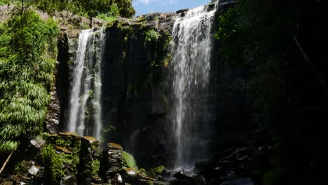 Idyllischer-Kerikeri-Wasserfall,-Der-An-Sonnigen-Tagen-Und-Blauem-Himmel-In-Neuseeland-Ins-Tal-Fällt---Filmmaterial-Nach-Unten-Kippen
