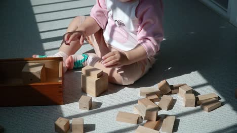 Kleinkind-Stapelt-Hölzerne-Spielzeugblöcke-Auf-Dem-Balkon---Multiethnische-Asiatische-Koreanisch-ukrainische-Babymädchenerziehung