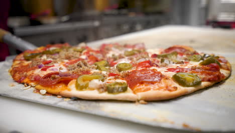 Pizzeria-Koch-Schneidet-Frisch-Gebackene,-Dampfend-Heiße-Pizza-Mit-Mezzaluna-Pizzaschneider-Aus-Edelstahl,-4k
