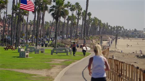 Blonde-lady-with-pony-tail-jogging-on-the-bike-path-in-Huntington-Beach,-California