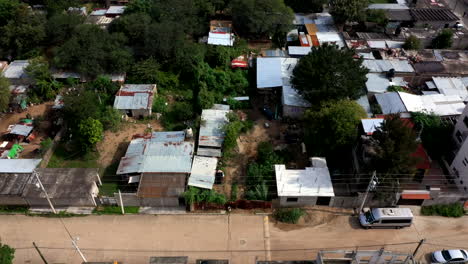Aerial-view-of-the-suburbs-of-the-city-of-Oaxaca-in-Mexico,-filmed-by-a-drone-with-tilt-up-displacement,-showing-a-poor-area-and-shack-homes