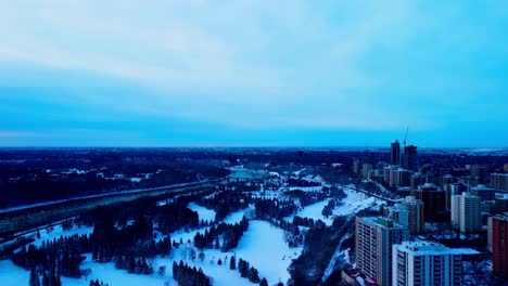 Winter-aerial-fly-over-the-recreational-park-for-cross-country-skiing-skating-and-sledding-from-a-repurposed-summer-use-of-golfing-and-team-activities-of-baseball-softball-at-the-rivers-of-dt-Edmonton