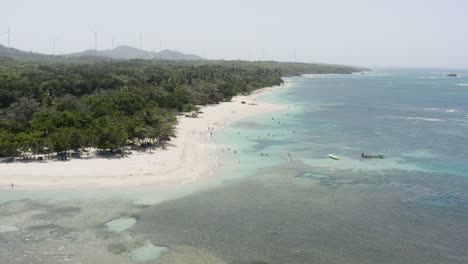 Turistas-Nadando-En-Un-Mar-Azul-Poco-Profundo-En-Playa-Teco-Maimon,-Una-Playa-Turística-De-Arena-Blanca-En-La-República-Dominicana