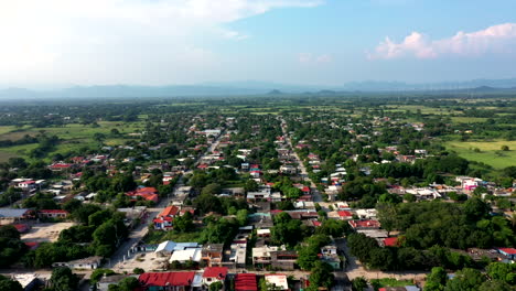 Aerial-wide-view-of-the-suburbs-of-the-city-of-Oaxaca-in-Mexico,-filmed-by-a-drone-with-forward-displacement-and-skyline-in-the-background