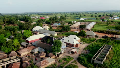 Rukubi-community-in-rural-Nigeria,-West-Africa-with-a-scenic-view-of-houses-and-farmland---aerial-ascending-view
