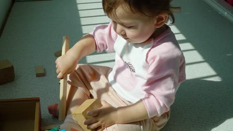 Babymädchen-Spielen-Holzspielzeug-Auf-Dem-Boden