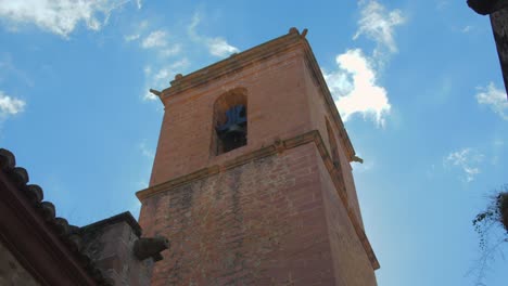 Panning-across-beautiful-historic-assumption-church-bell-tower-of-Vilafames-in-Castellon,-Spain