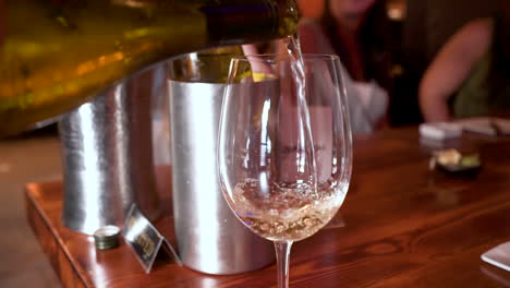 White-wine-pours-into-stemmed-wine-glass-at-dinner,-HD