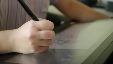 A-caucasian-woman's-hand-draws-a-digital-illustration-on-a-tablet-in-slow-motion
