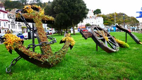 Flowery-anchor-wheel-and-propeller-display-making-word-joy-in-artistic-town-garden-sculpture