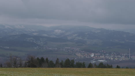 Blick-Auf-Felder-Und-Stadt-Im-Hintergrund,-Auf-Die-In-Zeitlupe-Frischer-Schnee-Fällt