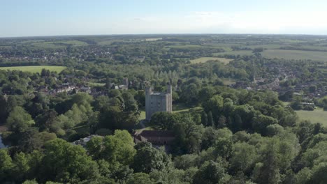 Stunning-Hedingham-Castle-in-England-surrounded-by-vibrant-green-forest-and-buildings