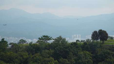 Boeing-CH-47-Chinook-cargo-helicopter-flying-over-Seoul-Achasan-mountain-peak-daytime
