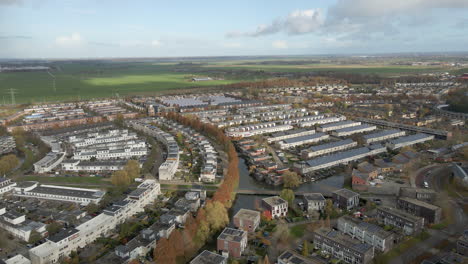 Aerial-dolly-of-a-suburban-area-with-rural-farmlands-in-the-background