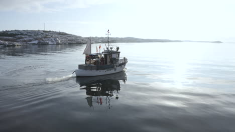 Drohnen-Nahaufnahme-Eines-Männlichen-Fischers,-Der-In-Einem-Kleinen-Weißen-Fischerboot-In-Der-Inselgemeinde-Öckerö-In-Den-Schären-Von-Göteborg,-Schweden,-Sitzt