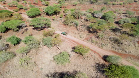 Drone-following-truck-driving-through-wilderness-in-rural-Kenya
