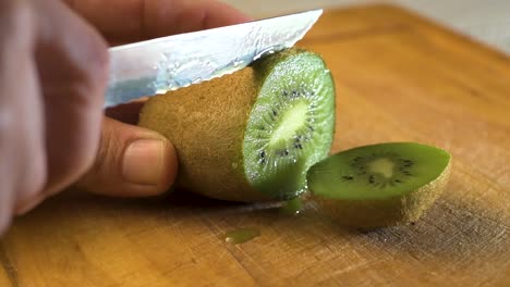 Cutting-delicious-kiwi-slices-on-a-wooden-board