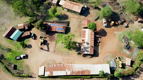 Top-down-aerial-of-sheds-and-warehouse-with-solar-panels-on-rooftop-on-an-African-construction-site