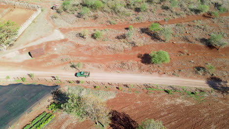 Aerial-of-truck-driving-past-farms-in-a-beautiful-African-landscape