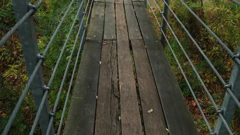 Suspension-bridge-over-a-river-in-the-woods-during-the-autumn-season