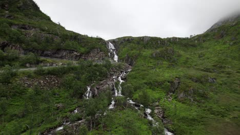 Flying-away-from-waterfall-in-narrow-valley-on-Senja-in-Norway