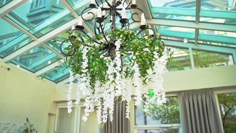 Beautiful-Elegant-Black-Metal-Chandelier-With-Hanging-Green-Leaves-And-White-Flowers