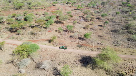 High-angle-pan-of-truck-driving-through-wilderness-in-rural-Kenya
