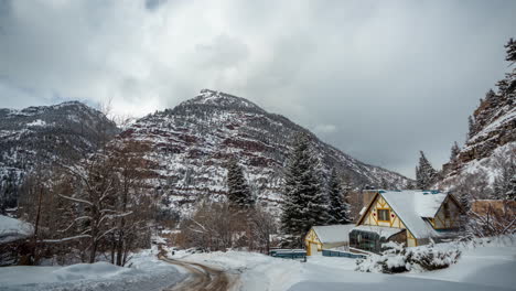 Time-Lapse,-Idyllic-Winter-Scenery,-Mountain-House,-Snow-Capped-Hills-and-Countryside-Road,-Colorado-USA