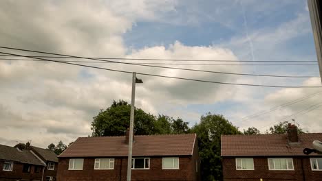 very-animated-clouds-with-an-english-red-brick-housing-and-powerlines-in-shot