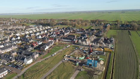 Luftaufnahme-Der-Baustelle-Am-Rande-Eines-Neu-Gebauten-Vorortviertels,-Umgeben-Von-Grünen-Wiesen-In-Der-Holländischen-Landschaft