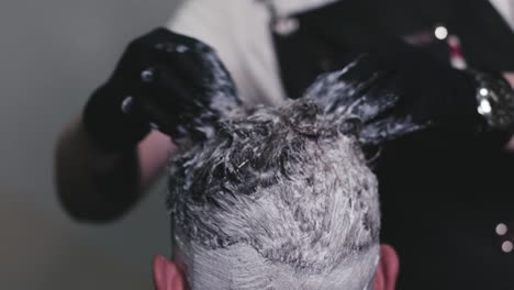 Dyeing-the-hair-of-a-young-man-by-a-professional-hairdresser-using-his-hands