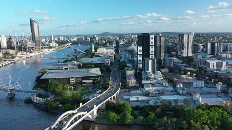Drone-pull-away-shot-of-William-Jolly-Bridge,-with-South-Bank,-West-end-and-Brisbane-CBD-and-River-all-in-shot