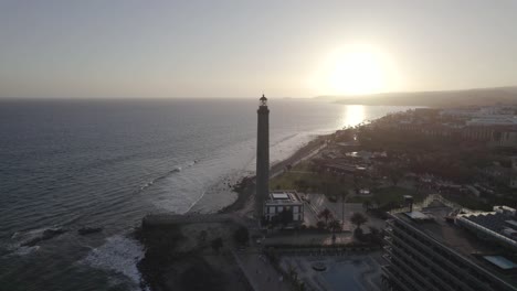 Luftaufnahme-Des-Historischen-Leuchtturms-Von-Maspalomas-Auf-Den-Kanarischen-Inseln,-Sonnenuntergangshintergrund